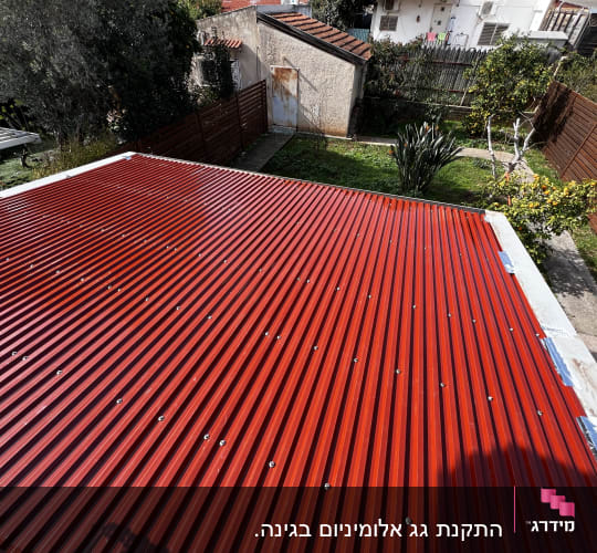 גג מתכת אדום עם ברגים בגינה